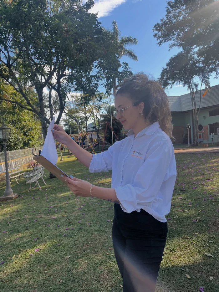 Camila analisando documentos durante uma atividade em campo.